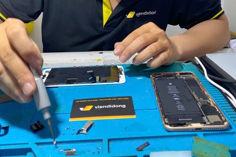Kỹ thuật viên thực hiện thao tác lách màng film để tách màn hình AMOLED khỏi khung sườn hỏng.